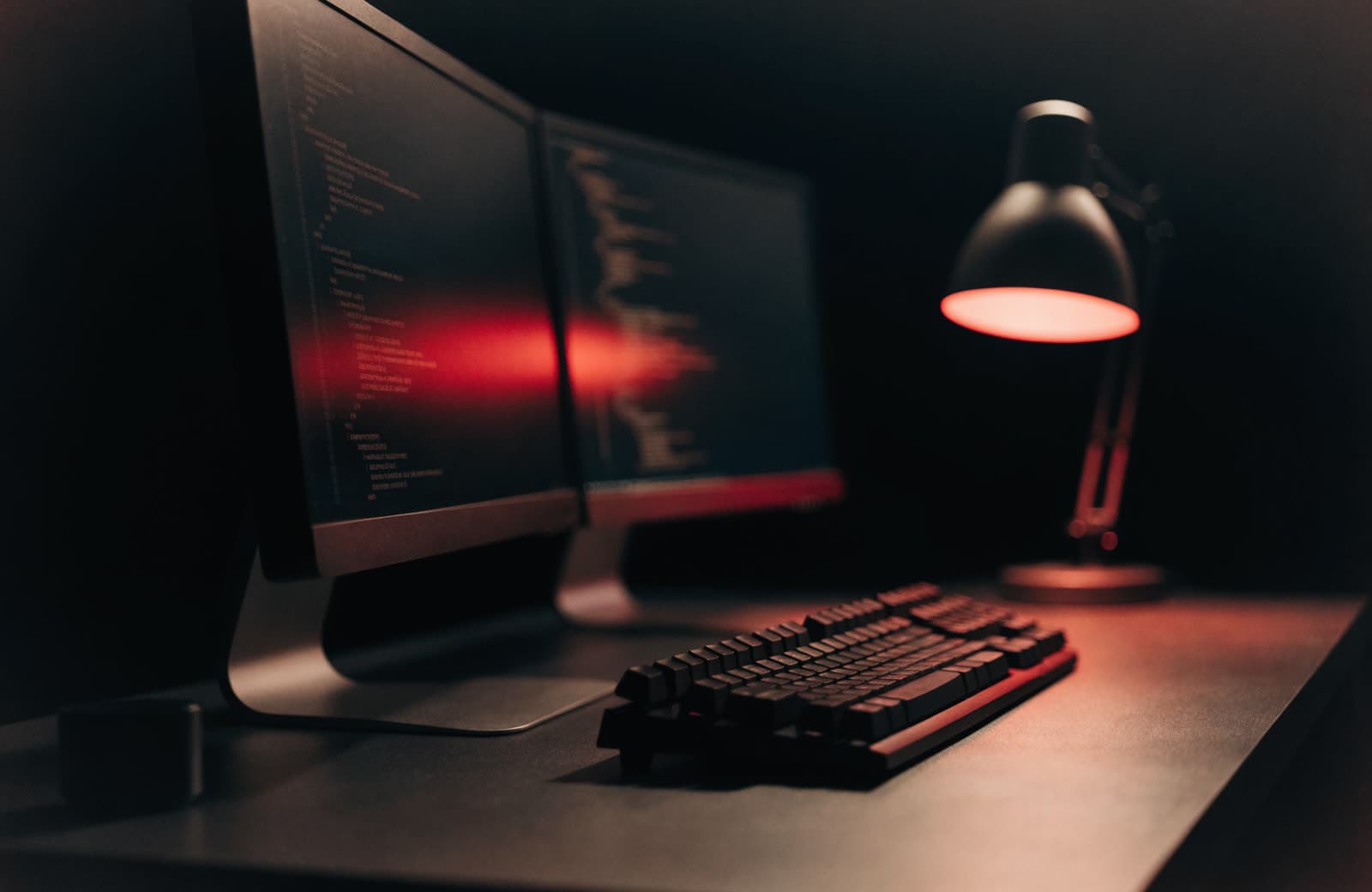 A developer desk with dual monitors and warm lighting
